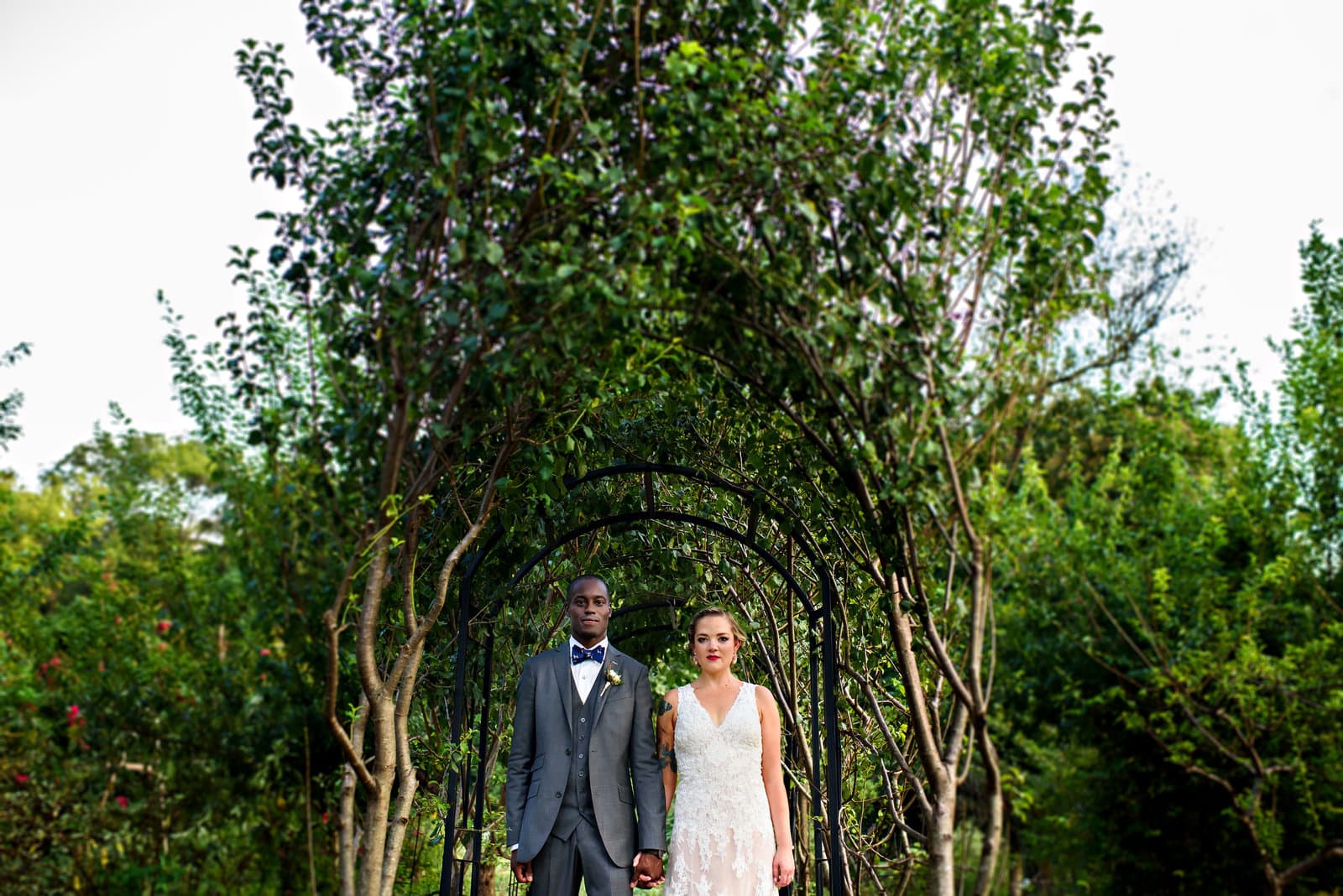 Newlyweds beneath a garden archway on their wedding day